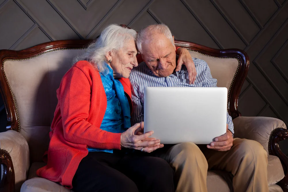 Lovely senior man and woman holding a laptop understanding the difference between a Will Just as Good as a Trust
